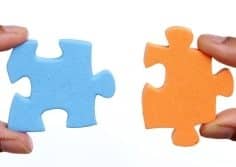 Blue puzzle piece plugging or fitting into orange puzzle piece.